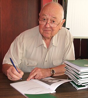 Jānis Klētnieks parakstot vienu no savām grāmatām, 2007. Foto: Ilgonis Vilks